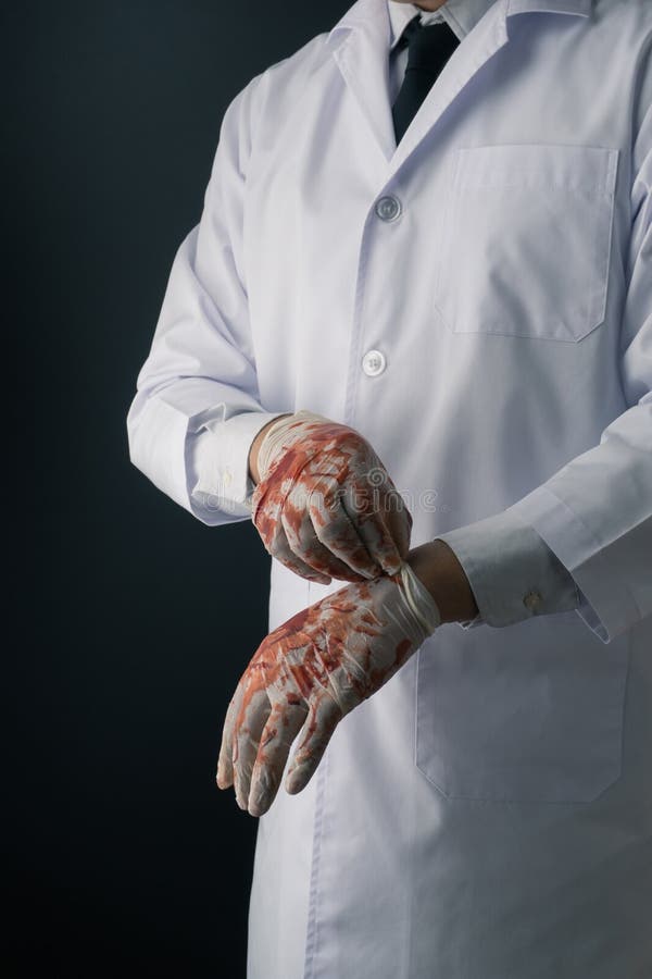 Ein Doktor im weißen Mantel, der blutige Latexhandschuhe trägt stockbild Ein Doktor im weißen Mantel, der blutige Latexhandschuhe trägt stockbild
