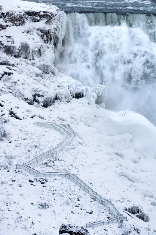 Ein eisiger Weg, der eine Spur in Richtung zu einem riesigen Wasserfallamerikaner führt, stellt sich heraus, dass die Niagarafälle stockfotos