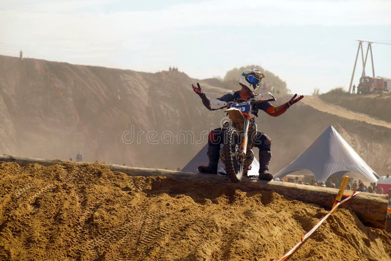 Ein erfolgloser Konkurrent verbreitet seine Hände hilflos Er erhielt in einem Hindernis gehaftet Motorradwettbewerb stockfotos Ein erfolgloser Konkurrent verbreitet seine Hände hilflos Er erhielt in einem Hindernis gehaftet Motorradwettbewerb stockfotos