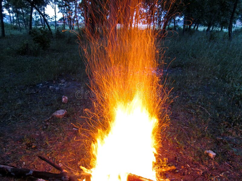 Ein Feuer in einem dunklen Wald funkelt am Abend eine Vielzahl orange Threads von den Spuren von Funken bildend stockfoto Ein Feuer in einem dunklen Wald funkelt am Abend eine Vielzahl orange Threads von den Spuren von Funken bildend stockfoto