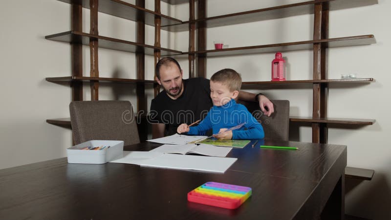 Ein fünfjähriger Junge und sein Vater machen Hausaufgaben