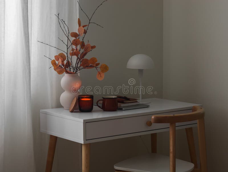 Ein gemütliches Herbstleben in einer Vase mit Herbstbukett, einer beleuchteten Kerze, Kaffeekanne auf einem Laptop auf einem weiße stockbild