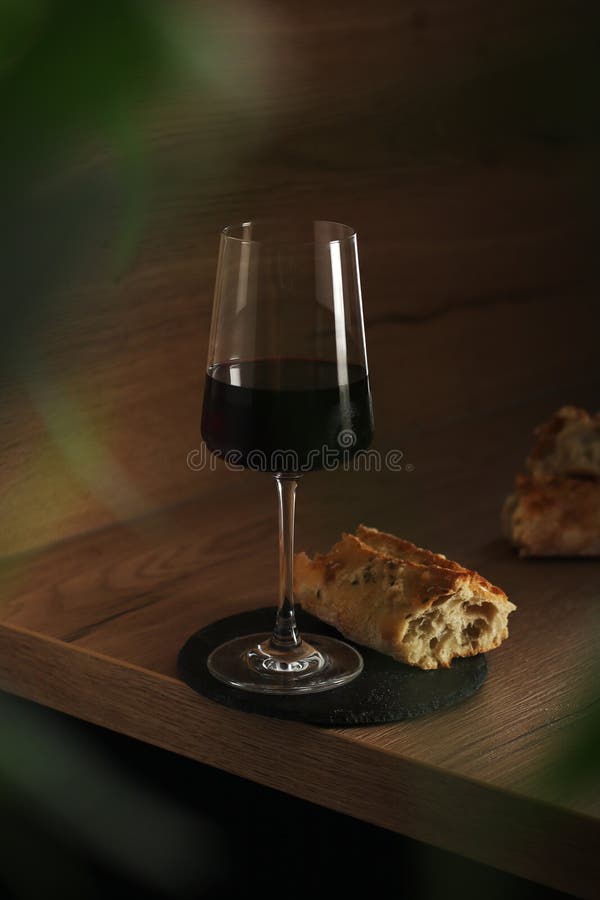 Ein Glas Wein mit Brot im minimalistischen Stil lizenzfreie stockfotos