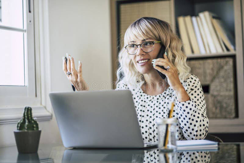 Ein glücklicher junger Erwachsener frei bei der Arbeit zu Hause. Profi-Frau mit Laptop, die Remote-Clients anruft. Hilfe lizenzfreie stockfotografie