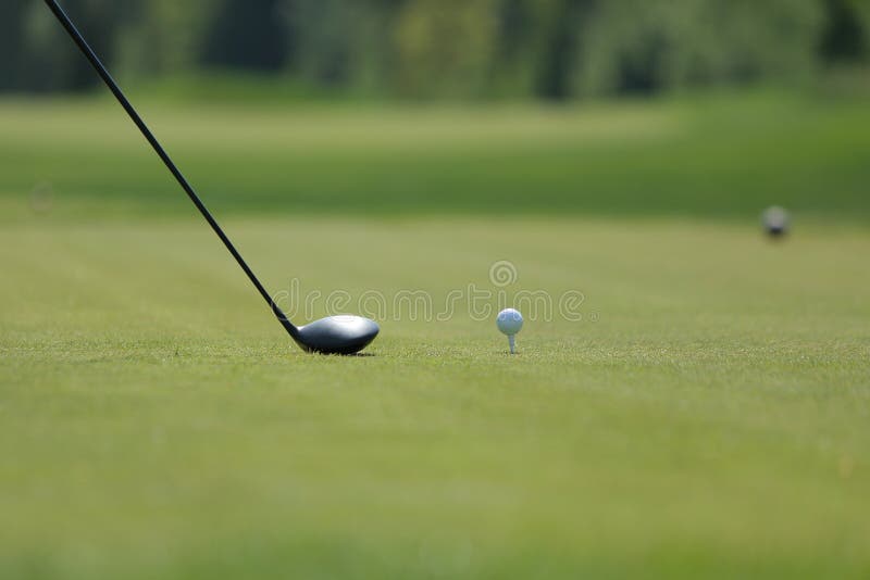 Ein Golffahrer mit Ball auf einem T-Stück auf dem Golfplatz stockfoto Ein Golffahrer mit Ball auf einem T-Stück auf dem Golfplatz stockfoto