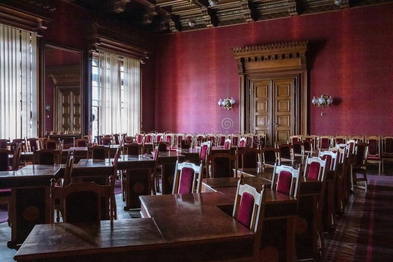 Ein großer Saal mit zahlreichen Holzstühlen und -tischen stockbild