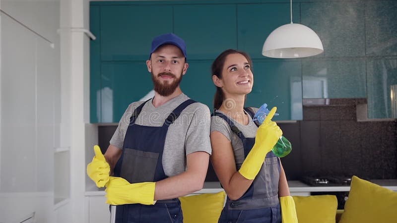 Ein gutes Team von Reinigern in blauen Uniformen, die mitten in der Küche stehen