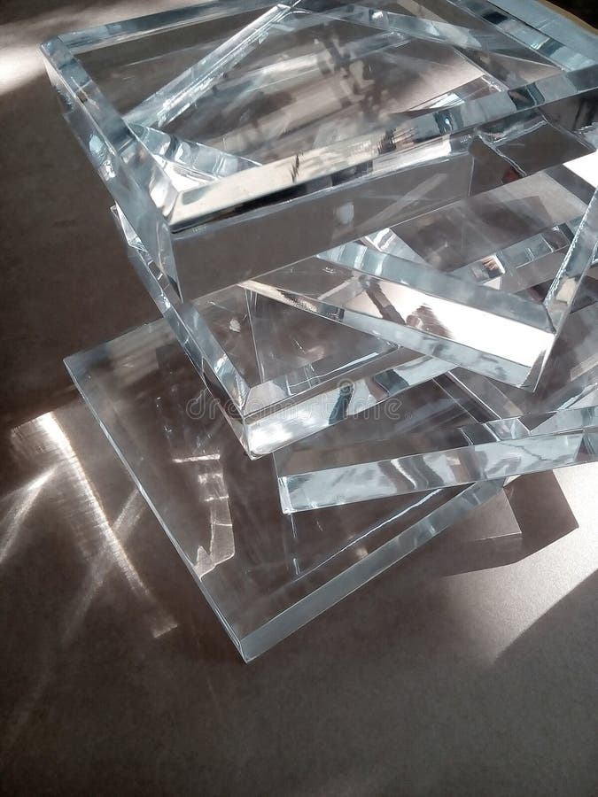 a pile of clear glass acrylic pieces on a table with the effect of sunlight. a pile of clear glass acrylic pieces on a table with the effect of sunlight