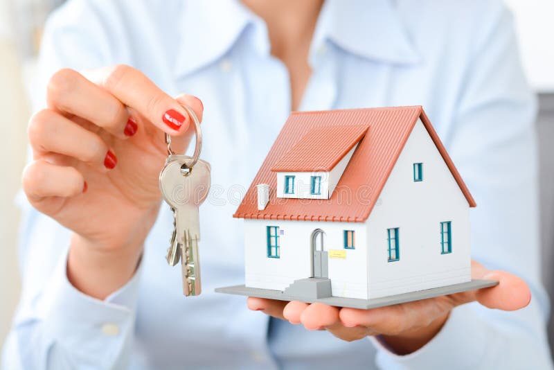 Buying a house concept with woman hands holding a model house and house keys. Buying a house concept with woman hands holding a model house and house keys