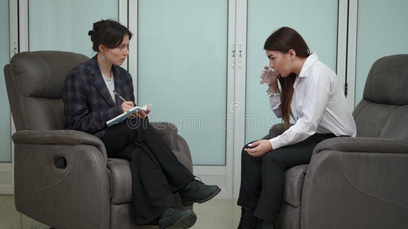 Ein Instruktionspsychologe hört auf die Probleme eines Mädchens im Team des Unternehmens, das im Innenbereich vor jedem stock video footage