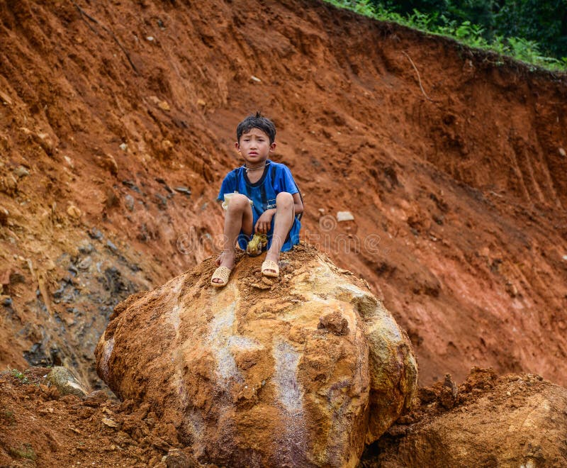 Ein Junge, der auf Felsen in Sa-PA, Vietnam sitzt stockfotografie Ein Junge, der auf Felsen in Sa-PA, Vietnam sitzt stockfotografie