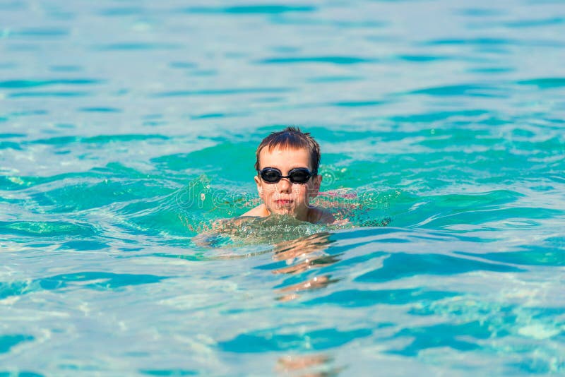 Ein Junge schwimmt und amüsiert sich im Meer in der Nähe des Ufers stockfoto