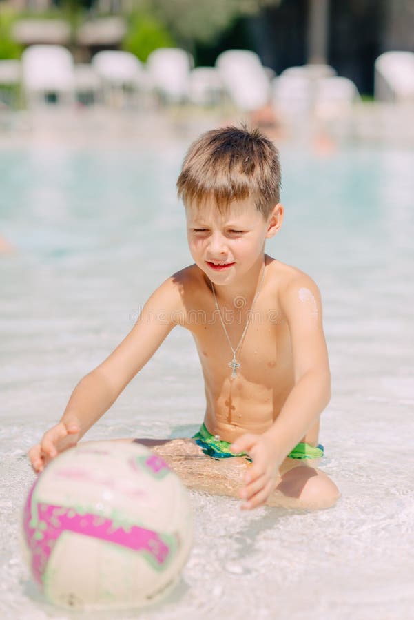 Ein Junge Spielt Mit Einem Ball Im Wasser Stockfoto - Bild von