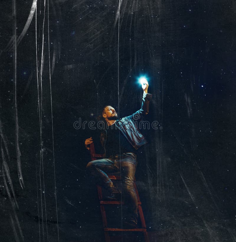 Ein junger Mann mit einem Bart auf der Treppe hält einen Stern vor dem hintergrund des nächtlichen Himmels mit Kratzern Kreatives lizenzfreie stockfotos