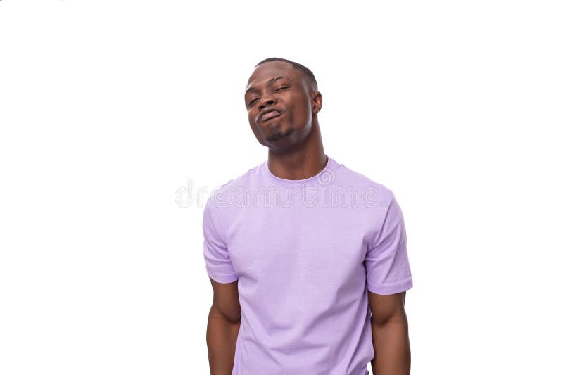 Ein junger stolzer Amerikaner, gekleidet in einem leichten lila Hemd, macht einen Grimace stockfotos