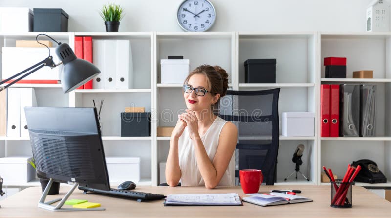 Ein junges Mädchen sitzt am Schreibtisch im Büro stockfotografie