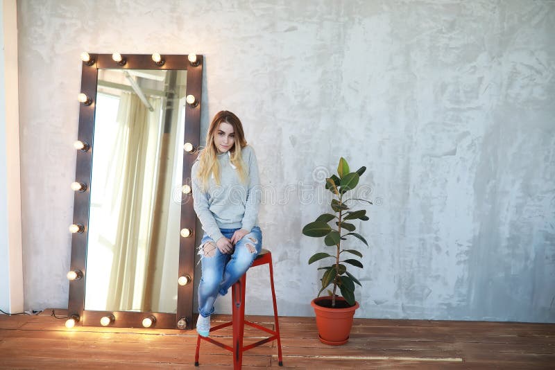 Ein junges Mädchen steht in einem gemütlichen Raum still lizenzfreies stockfoto Ein junges Mädchen steht in einem gemütlichen Raum still lizenzfreies stockfoto