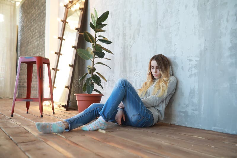 Ein junges Mädchen steht in einem gemütlichen Raum still lizenzfreie stockfotografie Ein junges Mädchen steht in einem gemütlichen Raum still lizenzfreie stockfotografie