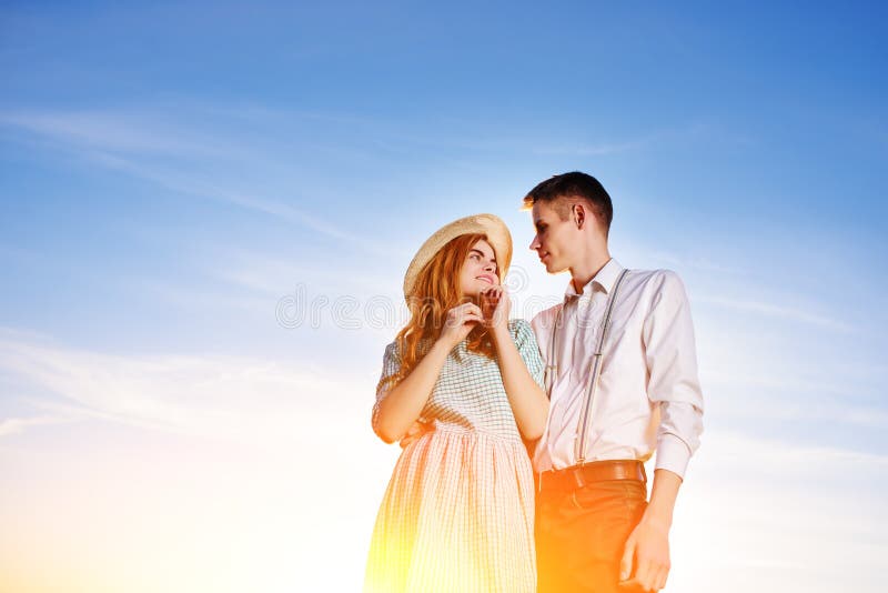 Ein junges Paar, das gegen einen Hintergrund des blauen Himmels steht stockfoto Ein junges Paar, das gegen einen Hintergrund des blauen Himmels steht stockfoto