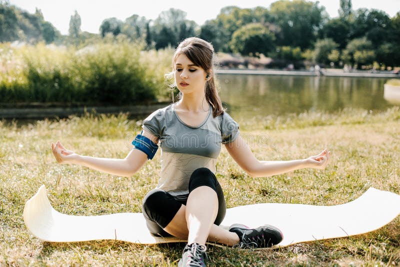 Ein junges und schönes Mädchen, das Sport im Freien tut Im Park führt das Mädchen Sportübungen durch stockbild Ein junges und schönes Mädchen, das Sport im Freien tut Im Park führt das Mädchen Sportübungen durch stockbild