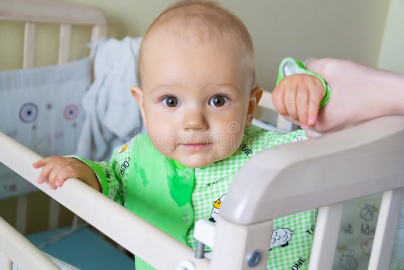 Ein jähriges Baby sitzt und schaut aufmerksam irgendwo Kleiner netter Junge in einer hellgrünen Klage mit Schafen lizenzfreie stockbilder Ein jähriges Baby sitzt und schaut aufmerksam irgendwo Kleiner netter Junge in einer hellgrünen Klage mit Schafen lizenzfreie stockbilder