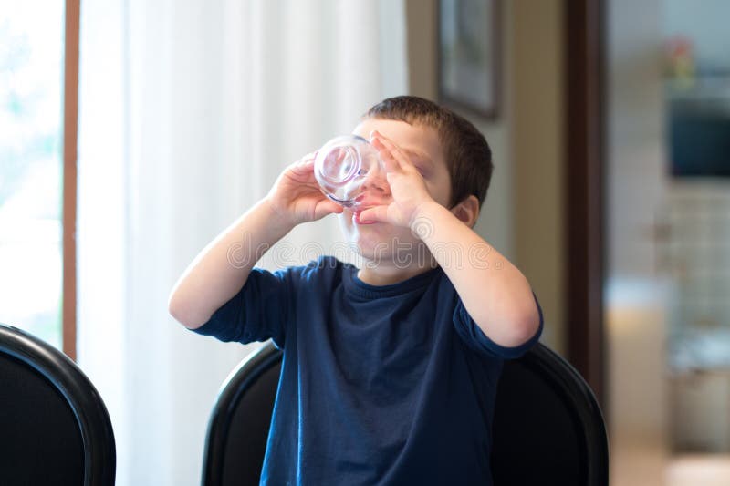 Ein Kind trinkt ein Glas Wasser stockfotografie Ein Kind trinkt ein Glas Wasser stockfotografie