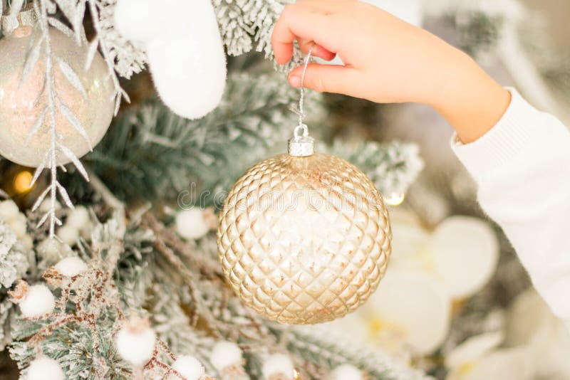 Ein Kind und ein Erwachsener schmücken einen Weihnachtsbaum Eine goldene Weihnachtsbälle in der Hand eines Kindes Alle Ornamente stockfotos Ein Kind und ein Erwachsener schmücken einen Weihnachtsbaum Eine goldene Weihnachtsbälle in der Hand eines Kindes Alle Ornamente stockfotos