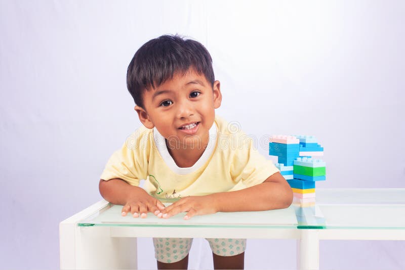 Ein kleiner asiatischer Junge, der mit bunten Plastikblöcken spielt stockfoto Ein kleiner asiatischer Junge, der mit bunten Plastikblöcken spielt stockfoto
