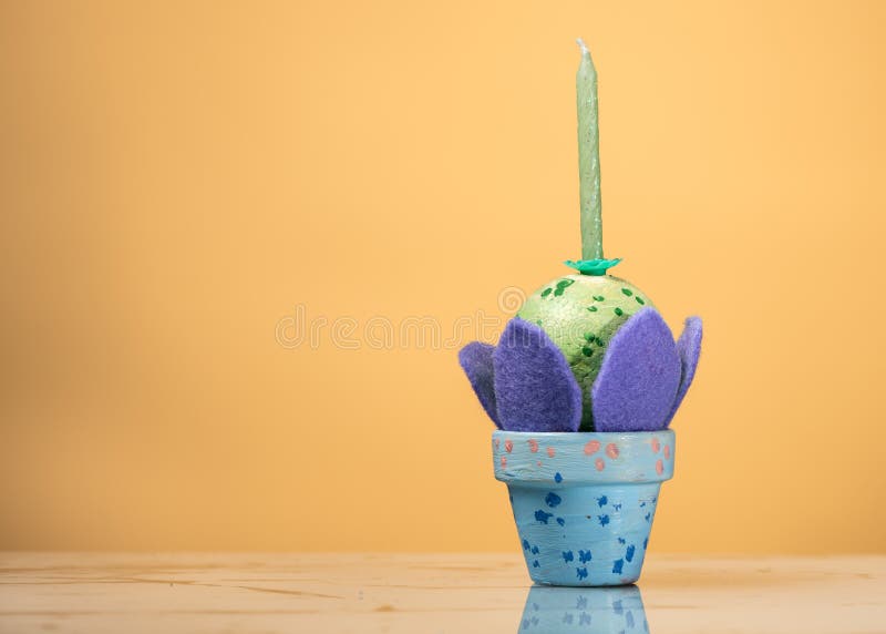 Ein kleiner blauer Eihalter mit einem grünen Osterei und einer Kerze lizenzfreie stockbilder Ein kleiner blauer Eihalter mit einem grünen Osterei und einer Kerze lizenzfreie stockbilder
