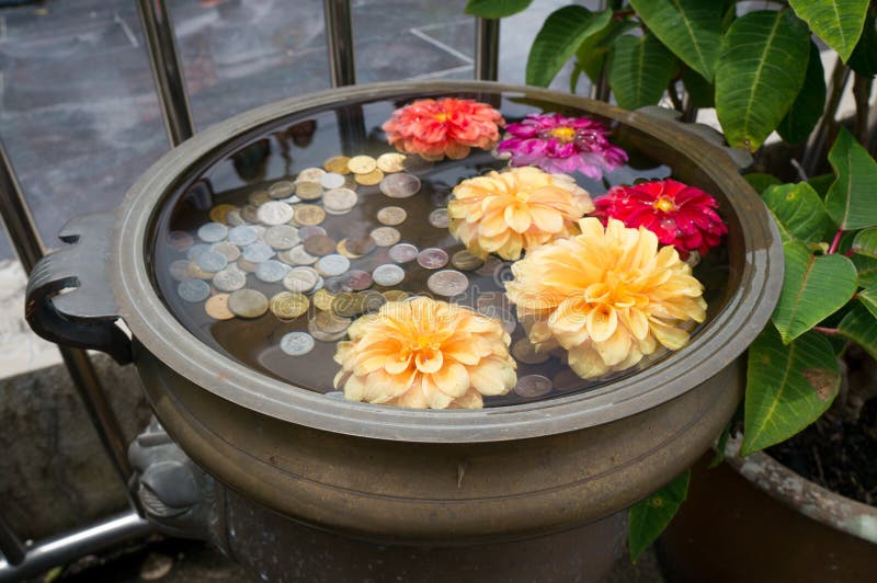 Ein kleiner Blumenwunschbrunnen mit Münzen auf Penang-Hügel stockfoto Ein kleiner Blumenwunschbrunnen mit Münzen auf Penang-Hügel stockfoto