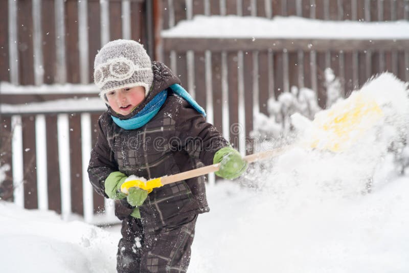Ein kleiner Junge s?ubert Wege einer Schaufel im Yard vom Schnee stockfotografie Ein kleiner Junge s?ubert Wege einer Schaufel im Yard vom Schnee stockfotografie