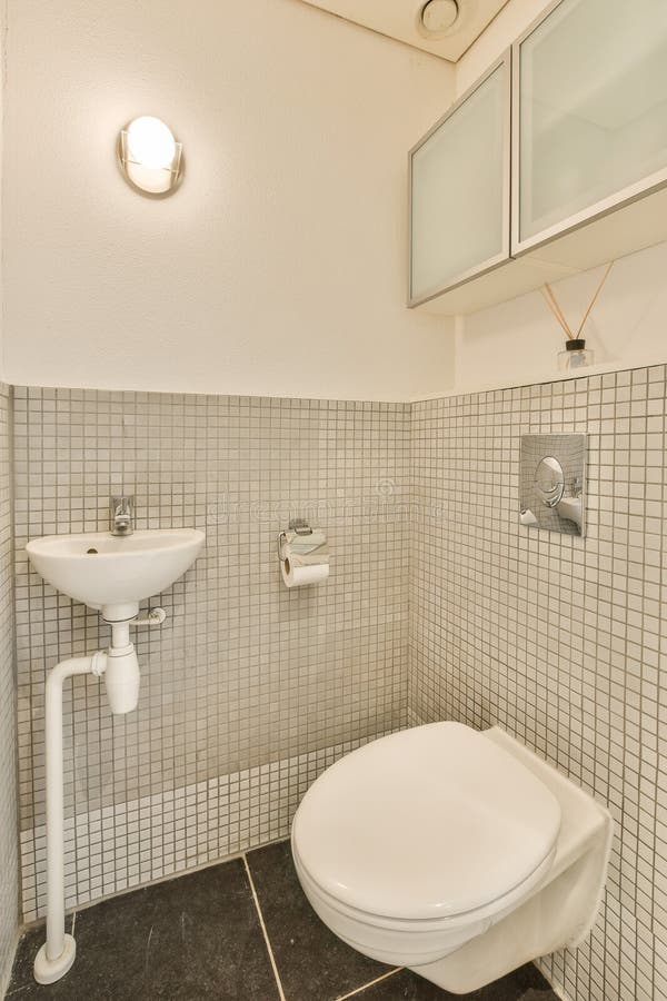 Ein kleines Badezimmer mit WC und Waschbecken stockfotos