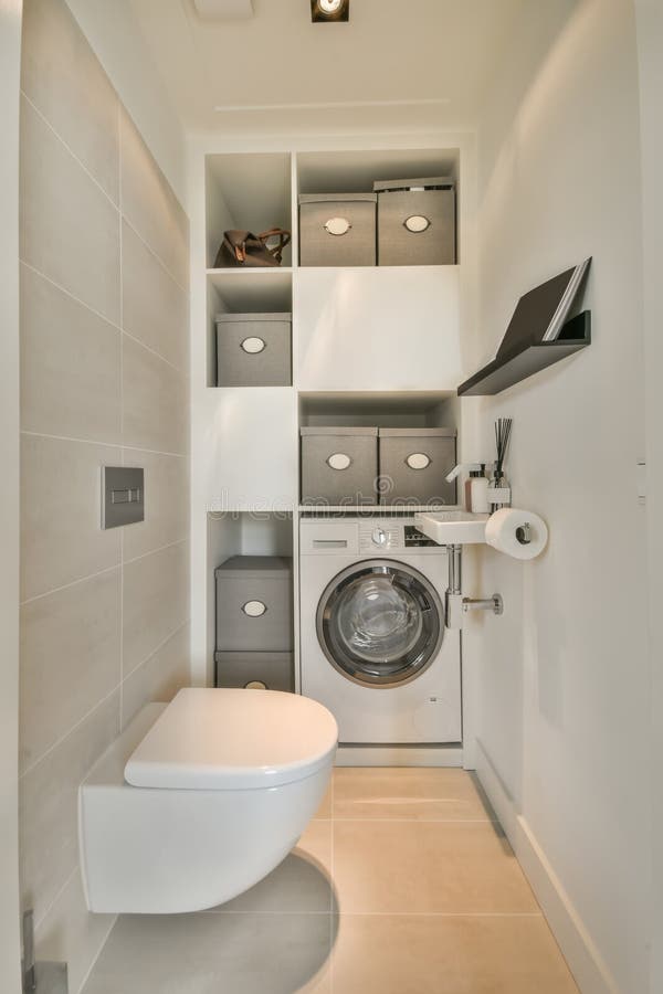 Ein kleines Badezimmer mit WC und Waschmaschine lizenzfreie stockfotos