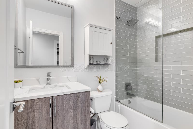 Ein kleines luxuriöses Badezimmer mit einer benutzerdefinierten Fliesendusche und weißem Marmor stockfoto