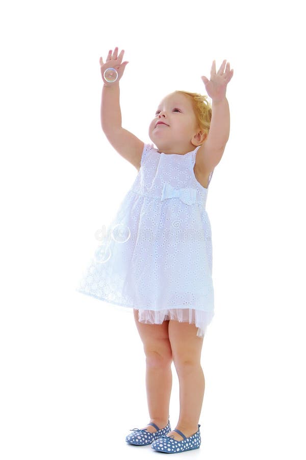 Ein kleines Mädchen fängt Seifenblasen stockfotografie Ein kleines Mädchen fängt Seifenblasen stockfotografie