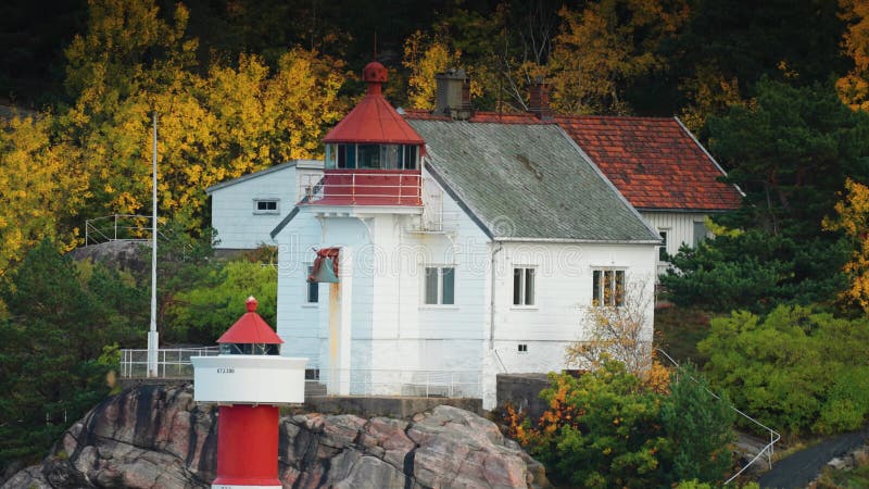 Ein Leuchtturm am Felsrand des Fjords.