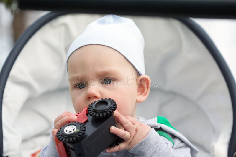 Ein lustiges kleines Baby in a in einem Kinderwagen lizenzfreie stockbilder Ein lustiges kleines Baby in a in einem Kinderwagen lizenzfreie stockbilder