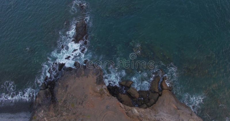 Ein malerischer Blick auf Felsen und stürmische Wellen am Ufer einer großen Insel. stockfotos