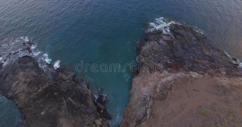 Ein malerischer Blick auf Felsen und stürmische Wellen am Ufer einer großen Insel. lizenzfreie stockbilder