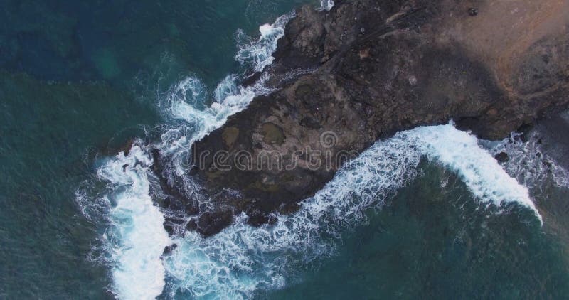 Ein malerischer Blick auf Felsen und stürmische Wellen am Ufer einer großen Insel. stockfotografie