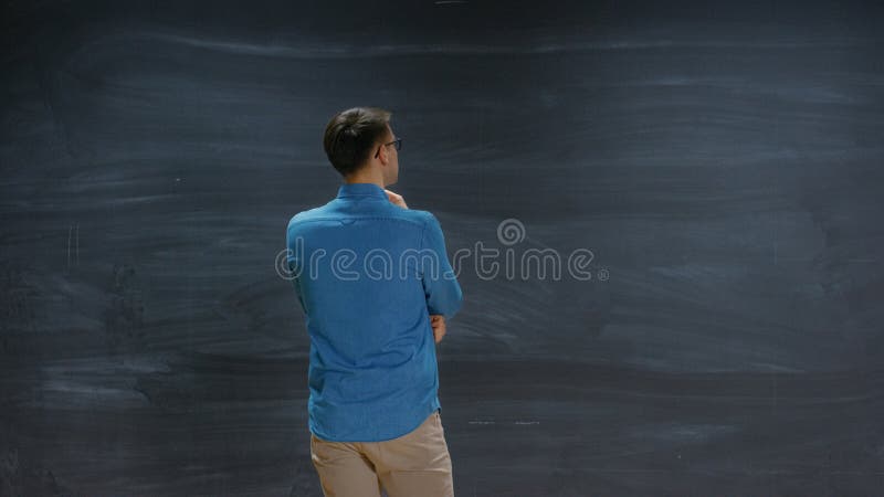 Ein Mann denkt vor einer leeren Tafel. stockfotografie