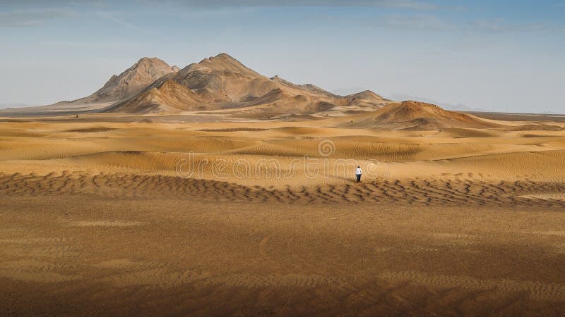 A man walking alone in the Dasht-e-Lut, a large salt desert located in the provinces of Kerman, Sistan and Baluchestan, Iran. A man walking alone in the Dasht-e-Lut, a large salt desert located in the provinces of Kerman, Sistan and Baluchestan, Iran