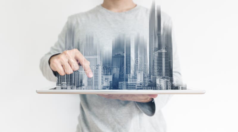 Ein Mann, der digitale Tablette verwenden, und modernes Gebäudehologramm Immobiliengeschäft und Bautechnologiekonzept lizenzfreies stockfoto