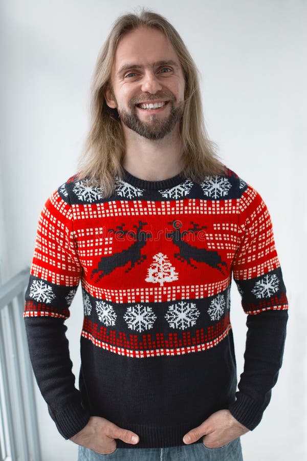 A man in a New Year`s sweater with a deer ornament. A man in a New Year`s sweater with a deer ornament.