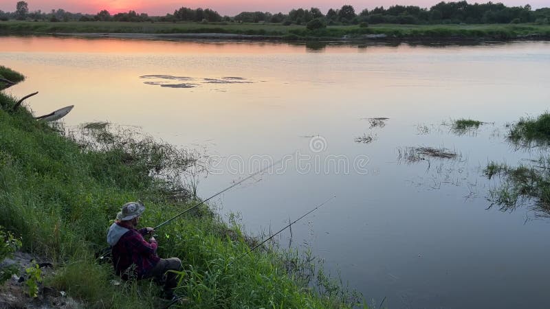 Ein Mann fischt an den Ufern eines großen Flusses.