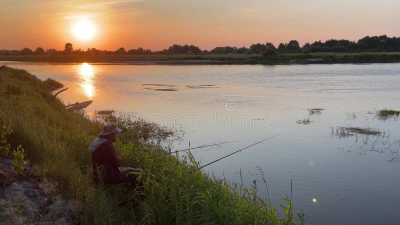 Ein Mann fischt an den Ufern eines großen Flusses.