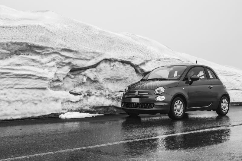Ein Mann fährt ein kleines Auto auf einer nass Straße im Gebirgsvulkan Ätna im Winter in Sizilien lizenzfreie stockbilder Ein Mann fährt ein kleines Auto auf einer nass Straße im Gebirgsvulkan Ätna im Winter in Sizilien lizenzfreie stockbilder