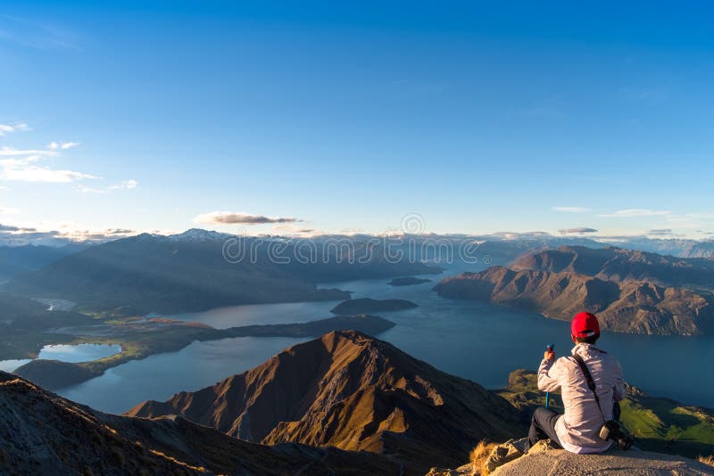 Ein Mann mit Blick auf die wunderschöne Landschaft der Berge und den Wanaka-See Roys Peak Track, South Island, Neuseeland I stockfotos
