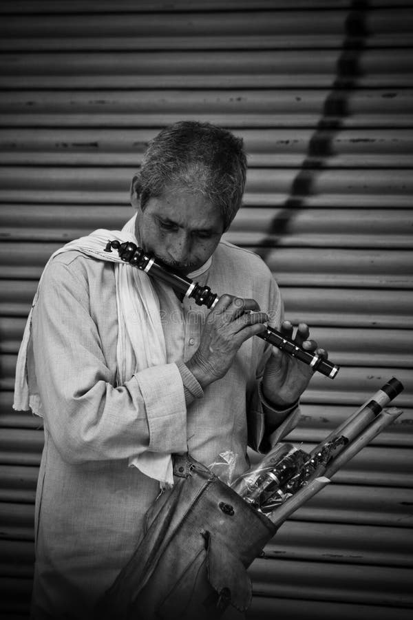 Ein Mann spielt eine Flöte, die bereit ist, auf den Straßen von Kathmandu, Nepal zu verkaufen lizenzfreie stockfotografie Ein Mann spielt eine Flöte, die bereit ist, auf den Straßen von Kathmandu, Nepal zu verkaufen lizenzfreie stockfotografie