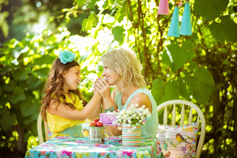Ein mather und eine Tochter halten Hände und schauen miteinander im Garten stockfotografie Ein mather und eine Tochter halten Hände und schauen miteinander im Garten stockfotografie